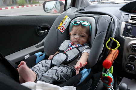 可爱的男婴坐在汽车座椅安全带锁保护驾驶公图片