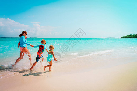 在热带海滩上与母亲和孩子一起图片