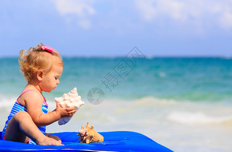 可爱的小女孩拿着贝壳图片