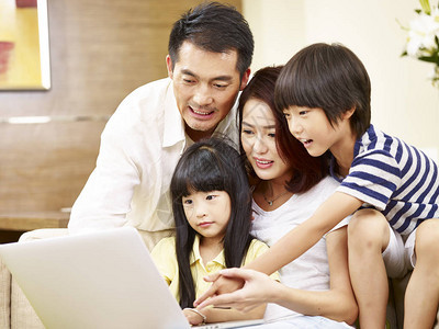 亚洲父母的父母和两个孩子的儿子和女儿一起坐在家庭沙发上使图片