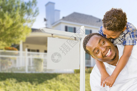 非洲裔美国父亲和混合种族之子在白衣房地产标志和新房背景图片