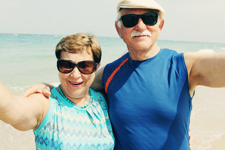 海滩上老年夫妇的自拍照背景图片