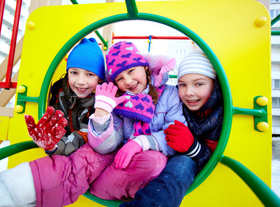 冬天穿冬装的快乐孩子在游乐场玩图片