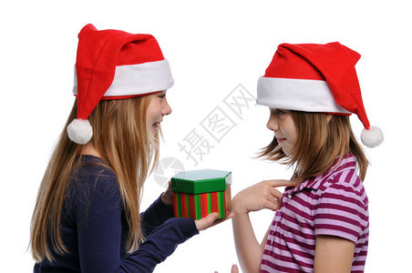 两个女孩分享圣诞礼物孤立在白色图片