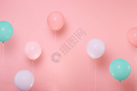 粉红色背景上糊色亮光的多彩气球生日节派背景图片