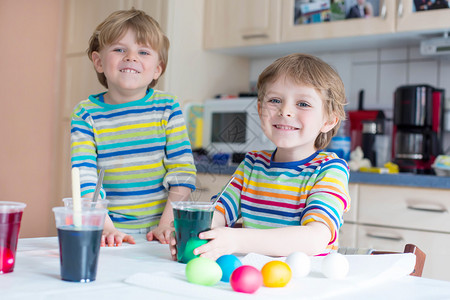 两个小双胞胎男孩在室内的家用里为复活节日配孩子们玩得开背景图片