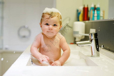 可爱的婴儿在洗水池洗澡图片