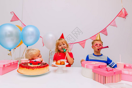 在生日派对上玩礼物和糖果的快乐的孩子图片