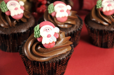 圣诞巧克力蛋糕和圣诞老人脸蛋在红色背景图片