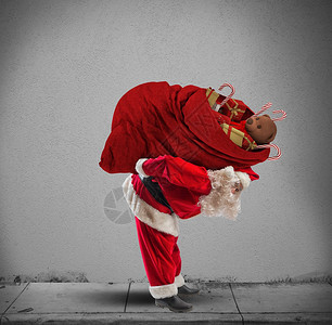 圣诞老人背着一个沉重的礼物红色麻袋图片