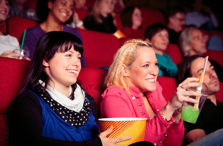 在电影院看着电影吃着爆米花的闺蜜图片
