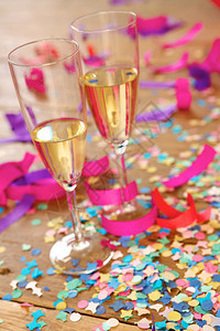 两个带有酒精和彩色纸屑装饰的香槟杯图片