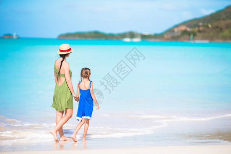 年轻美丽的母亲和可爱的小女儿在热带沙滩玩图片