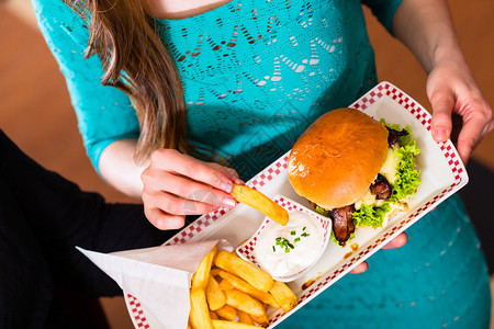 朋友或夫妇在美国快餐厅吃快餐汉堡背景图片