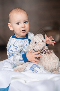 可爱的小男孩在玩泰迪熊玩具图片
