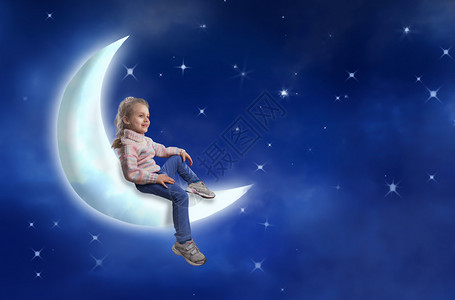 漂亮的小女孩坐在月亮上映衬着星空背景图片