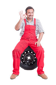 机械师坐在被白色隔开的轮胎上图片