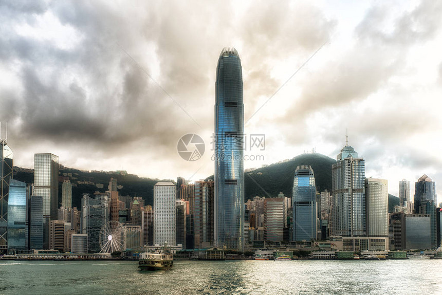 香港口的一艘渡轮背景是城市天际线图片
