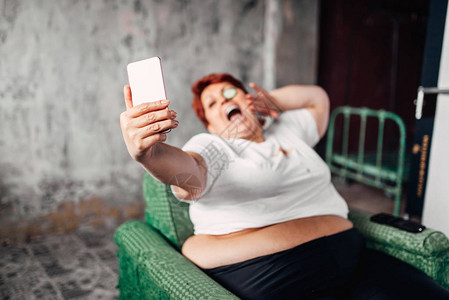 超重妇女采取自拍懒惰和肥胖不健康图片
