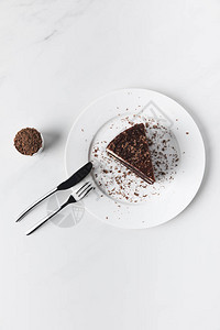 碗里磨碎的巧克力和盘子上釉的蛋糕图片