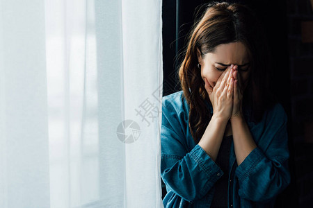 沮丧的女人在家里哭着捂脸图片