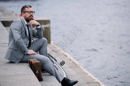穿着灰色西装的英俊帅气的生意人坐在图片