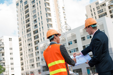 建筑师和客户讨论建筑工地的建筑计划图片