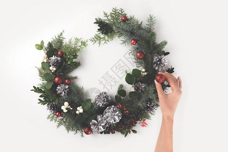 切成以鲜树枝圣诞球松果和寄生虫为单位的手制作圣诞节花环的作物形视图片