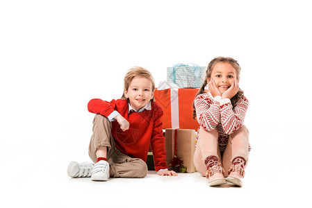 可爱的小孩坐在地板上带着一大堆圣诞礼物图片