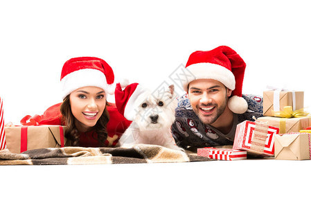 几对年轻夫妇躺在地板上与狗和圣诞礼物图片