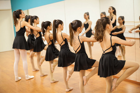 参加学校舞蹈班照镜子看自己一眼的许多小女孩排成一排背景图片