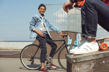快乐的青少年在滑板公园骑自行车图片