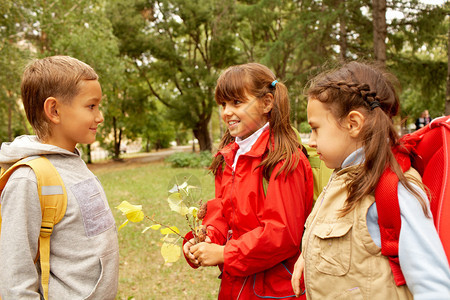 秋天公园里小学生聊天的画像图片