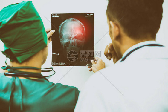 医生和外科医生检查病人脑部头骨或眼部受伤的X光片图片