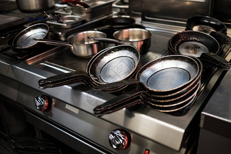 餐厅厨房的金属黑色平底锅用煤气做饭图片