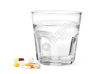 一杯水和白色上孤立的药丸图片