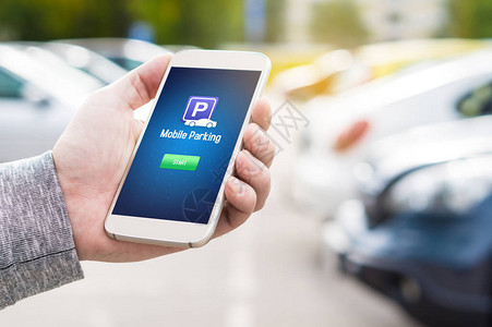 智能手机屏幕上的移动停车应用程序男子手持智能手机与停车场应用程序使用现代设备在线支付互联网背景图片
