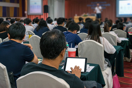 舞台上的演讲者在会议厅或研讨会议商业和教育概念中使用技术平板电脑图片