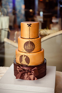 一个现代的复杂的婚礼蛋糕配有铜织品还有吊灯和舞伴合唱团的轮图片