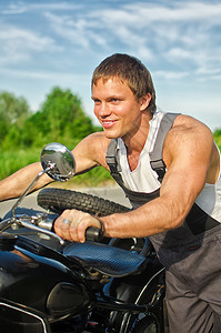 英俊的机械师推着摩托车的画像图片