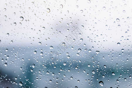 雨季在湿窗玻璃窗格表面上的雨滴抽象背景多云环境下室外模糊城市雨图片