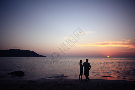 海边的日落两个人的剪影图片