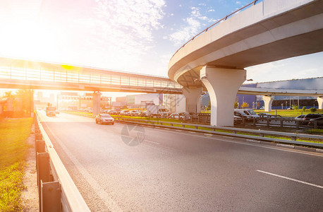 背景中与桥梁和太阳的高速公路交汇处图片