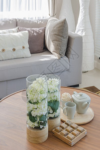 客厅木制圆桌上的植物玻璃花瓶和茶杯图片