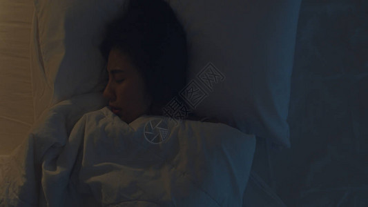 紧张的年轻亚洲女人半夜躺在家里卧室的床上做噩梦患有或偏失眠睡眠呼吸暂停或压力概念背景图片