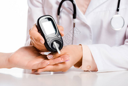 医生用基于糖尿病概念的血糖仪测量患者血液中葡萄糖水图片