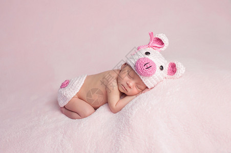 两周前刚出生的女婴穿着粉红编织和小猪装图片