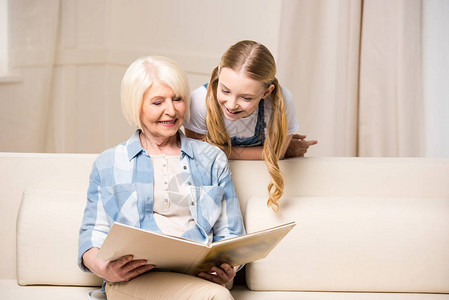 在家看相册的快乐祖母和孙女背景图片