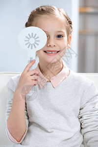 oculist咨询室儿童微笑检查视力和一只眼睛背景图片