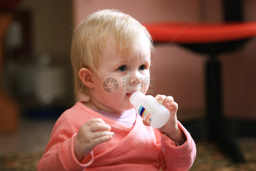 女婴蹒跚学步在家吃维生素或药丸长焦图片
